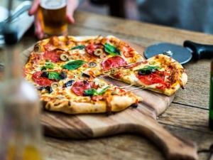 dos rebanadas de pizza en una tabla de cortar de madera en The Oakhill Inn, en Shepton Mallet