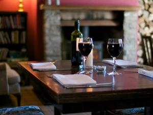 a table with two glasses of wine and a bottle of wine at The Oakhill Inn in Shepton Mallet