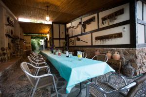 einen langen Tisch in einem Zimmer mit Stühlen und einer Wand in der Unterkunft Casa el Olivar de Don Pedro in Cobisa