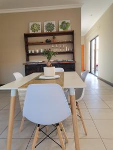 a dining room with a table and white chairs at Bread & Barrel Eureka Kimberley in Kimberley