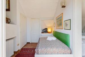 a small bedroom with a green bed in a room at ֍ Splendido Attico - Arsenale - con Terrazza ֍ in Venice