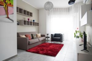 salon z kanapą i czerwonym dywanem w obiekcie YouHosty - Delle Genziane 7 w Mediolanie