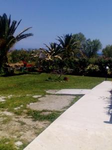 una acera que conduce a un parque con palmeras en Studios ΣΤΟΥΣ ΠΥΡΓΟΥΣ ΘΕΡΜΗΣ en Mitilene