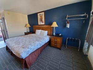 1 dormitorio con cama y pared azul en Water Front Inn en Port Townsend