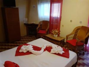 1 dormitorio con 1 cama con toallas rojas y blancas en SEIA Alojamentos Leitao, en Seia