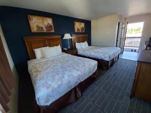a hotel room with two beds and a balcony at Water Front Inn in Port Townsend