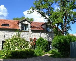 a brick house with a tree and some bushes at Ferme des Vallees in Soindres