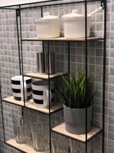 a shelf with pots and pans and plants on it at Apartman Spring in Sombor