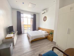 ein Schlafzimmer mit einem Bett und einem großen Fenster in der Unterkunft Vien Hotel in Cần Thơ