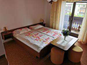 - une chambre avec un lit, une table et une fenêtre dans l'établissement Apartment Žvab, à Bohinj