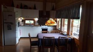 a kitchen with a table and chairs and a refrigerator at Savutaival in Pello