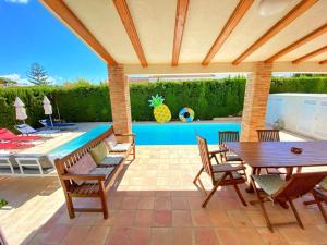 a patio with a table and chairs and a pool at Villa Los Balcones in Torrevieja