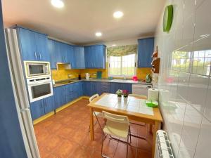 a kitchen with blue cabinets and a table and chairs at Villa Los Balcones in Torrevieja