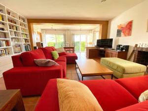 a living room with red couches and a tv at Villa Los Balcones in Torrevieja