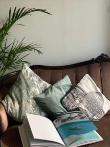 a book on a couch with pillows and a book at Wherever Mini Hostel in Rovaniemi