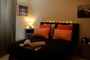 パトリモニオにあるChambre d'hôtes à 5mn des plagesのベッドルーム1室(赤とオレンジの枕が備わるベッド1台付)