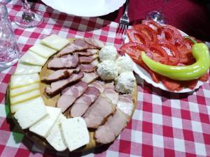a plate of food with meat and vegetables on a table at "Pivnica i smestaj Jovanovic"- Rogljevacke pivnice in Rogljevo