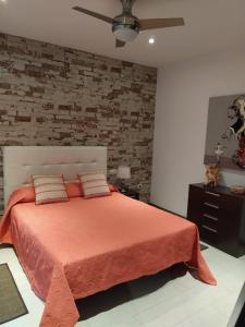 1 dormitorio con cama y pared de ladrillo en Villa FranyMar, en Lajares