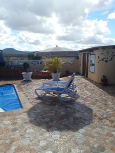 un sillón y una sombrilla junto a la piscina en Villa FranyMar, en Lajares