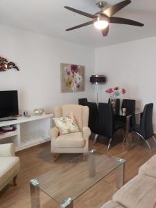 ein Wohnzimmer mit einem Stuhl und einem Tisch in der Unterkunft Apartamento Cuesta San Judas in Antequera