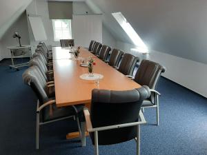 una sala de conferencias con una mesa larga y sillas en Garni Hotel Maselheimer Hof en Maselheim