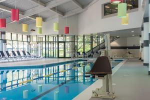 a swimming pool in a building with chairs around it at Crowne Plaza Princeton - Conference Center by IHG in Princeton