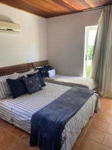 Un dormitorio con dos camas y una ventana. en Casa maravilhosa na praia de Muro Alto - Porto de Galinhas, en Porto de Galinhas