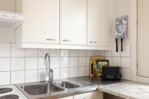 a kitchen with a sink and white cabinets at Tuure´s studio near to Art Museum in Turku