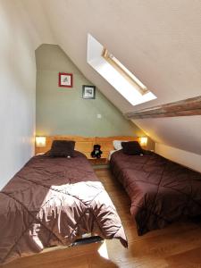 Un dormitorio abuhardillado con dos camas y una claraboya. en Duplex spacieux avec vue montagne au cœur de Cauterets, 6 à 8 pers, 3 chambres, 2 SDB, en Cauterets