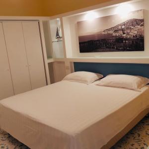 聖安吉洛的住宿－Casa Pozzillo，卧室内的一张大床,墙上有绘画作品