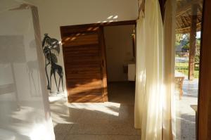 une porte menant à une chambre avec une girafe sur le mur. dans l'établissement Art Hotel Zanzibar, à Jambiani