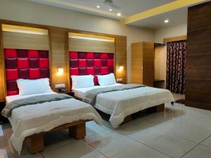 two beds in a hotel room with red headboards at HOTEL VIRAM in Pārdi