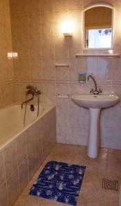 Kyiv Hotel في بولتافا: حمام مع حوض وحوض استحمام ومغسلة