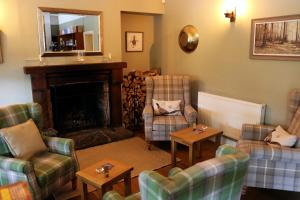 a living room with couches chairs and a fireplace at The Tollemache Arms in Buckminster