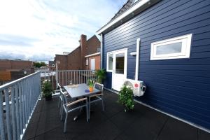 a balcony with a table and chairs on a blue building at Fantastic 90m2 Two-Bedroom Apartment with Terrace in Tiel