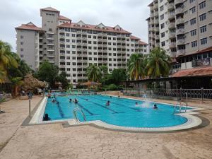 a group of people in a swimming pool with buildings at Glory Beach Resort PriVate PentHouse in Port Dickson