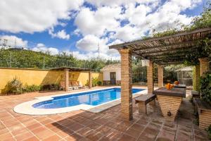 a backyard with a swimming pool and a pergola at Casa Rural Tita Ines in El Chorro