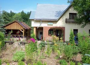 une maison avec un jardin en face dans l'établissement Pensiunea Casa Domniței Sucevița, à Suceviţa