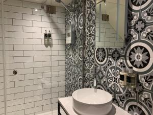 a bathroom with a white sink and a shower at The Balerno Inn in Edinburgh