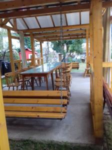 a wooden pavilion with a table and chairs at Passiflora in Voineasa