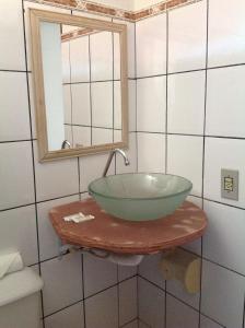 La salle de bains est pourvue d'un lavabo à bol vert sur une table. dans l'établissement Pousada Por do Sol, à Sao Jorge