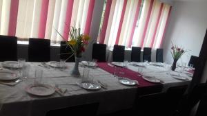 una mesa con platos y vasos encima en Passiflora, en Voineasa