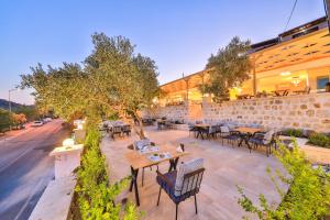 an outdoor patio with tables and chairs and a building at Hamarat Otel in Kaş