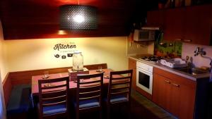 a kitchen with a table and chairs and a kitchen with a sink at Alpinejka House in Tržič