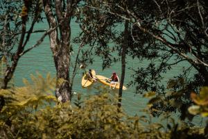 a man sitting on a paddle board in the water at The Boato Hotel in Guatapé