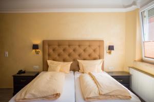 ein Schlafzimmer mit einem Bett mit zwei Kissen in der Unterkunft Hotel Heidelberger Hof in Heidelberg