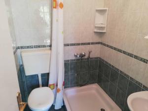 een badkamer met een bad, een toilet en een wastafel bij Apartments Sandra in Rab