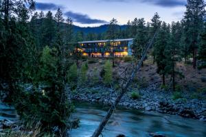 a bridge over a river in front of a building at Alpine Rivers Inn in Leavenworth