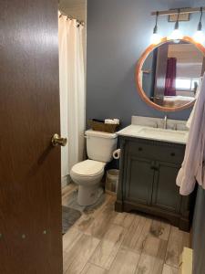 a bathroom with a toilet and a sink and a mirror at Beaver Village Apartment in Winter Park