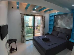 a bedroom with a black bed and a balcony at Cebu City Suites Ramos Tower by P&J in Cebu City